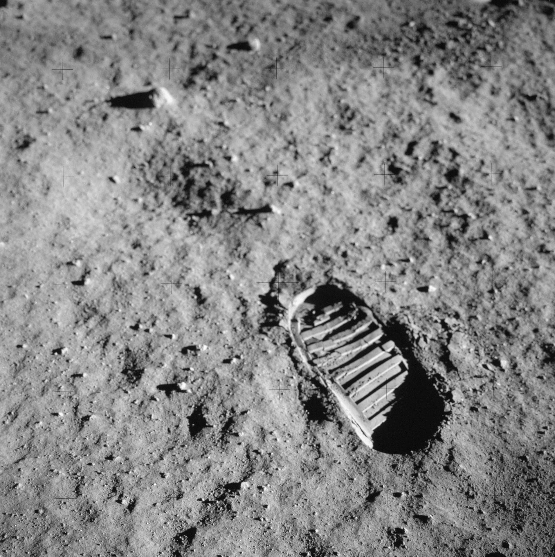 A single boot print pressed into fine lunar soil