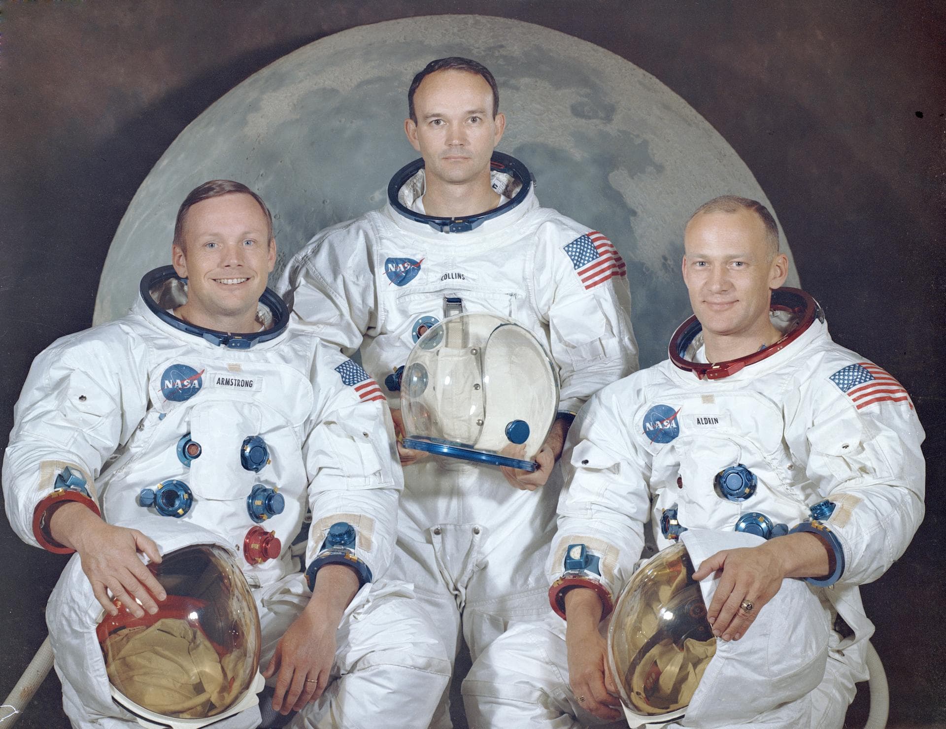 Official portrait of Neil Armstrong, Michael Collins, and Buzz Aldrin in white spacesuits