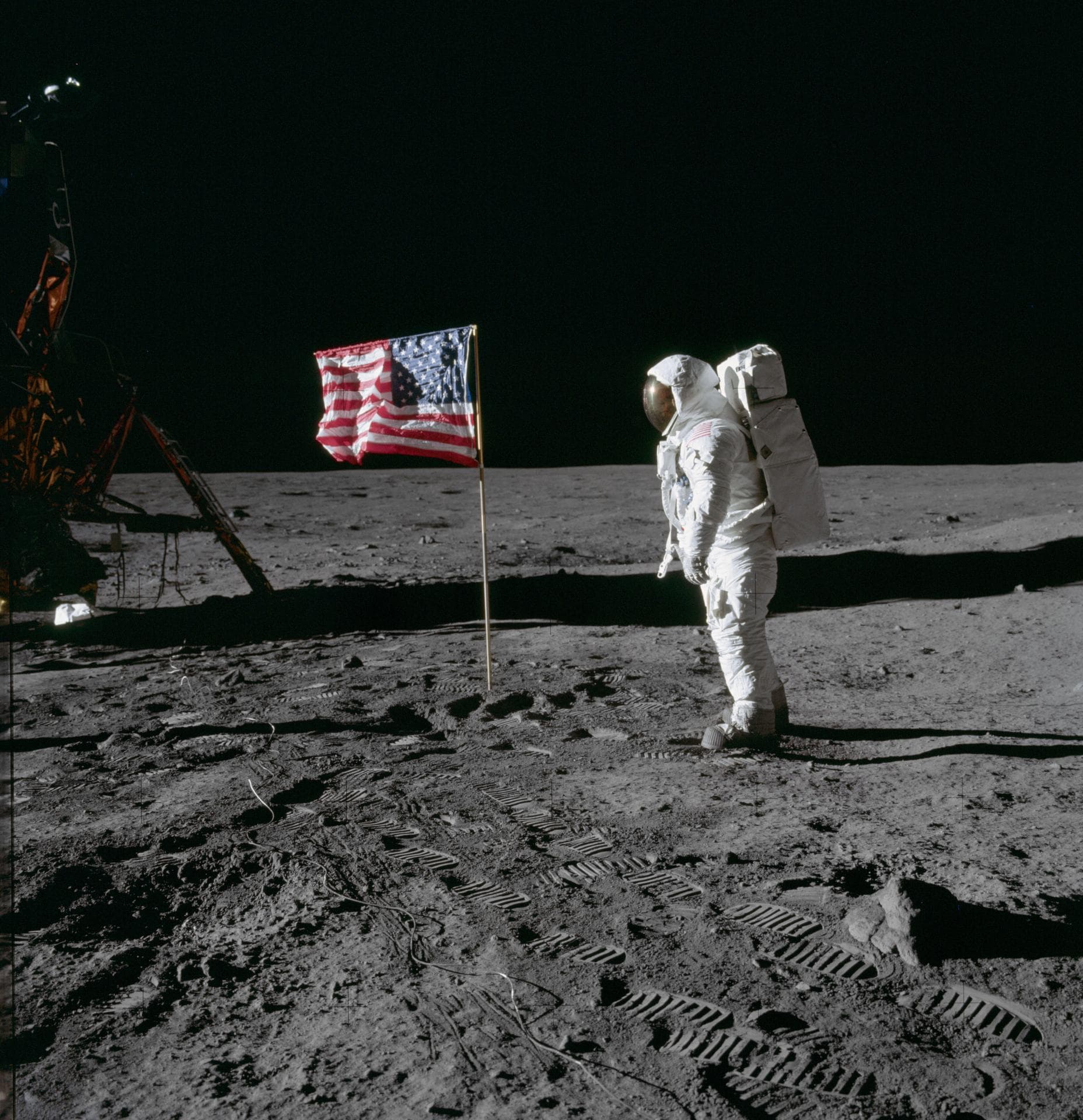 Buzz Aldrin beside the deployed United States flag, with the lunar module at left